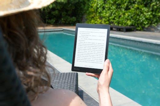 A woman relaxes by the pool, reading an e-reader for leisure. Perfect summer relaxation.